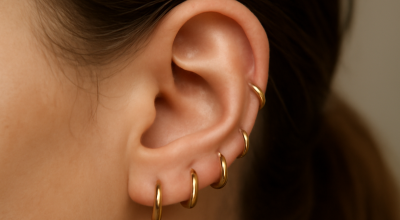 oreille avec plusieurs petites créoles assorties