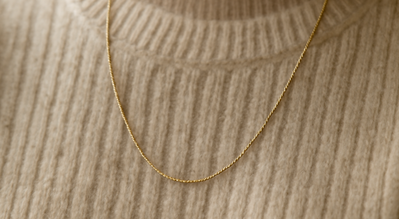 collier mince posé sur pull en maille