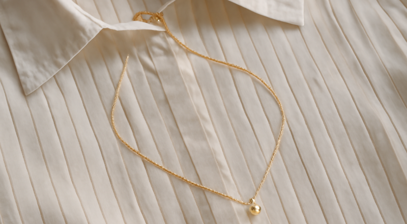 collier fin posé sur chemise plissée