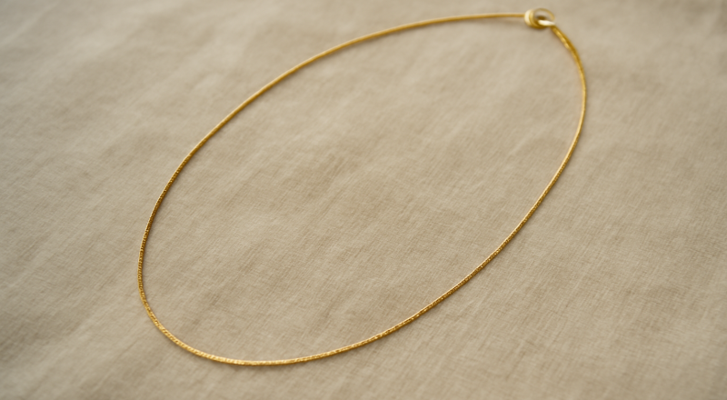 collier fin posé sur tissu neutre