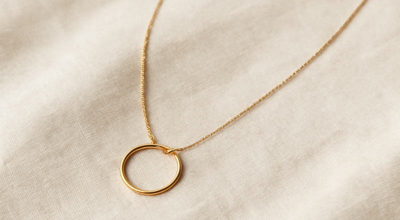 collier minimaliste posé sur un tissu neutre